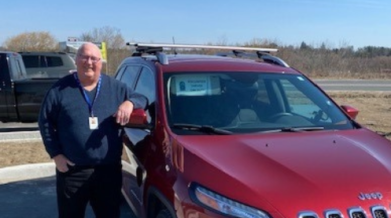 VON volunteer stands in front of car