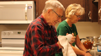 Bev at a sink doing dishes with a VON PSW. 