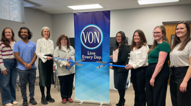 Group photo of staff with a ribbon cutting celebrating new clinic
