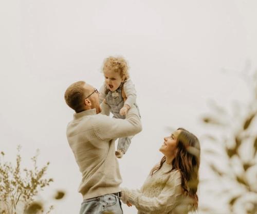 Parents holding toddler in air